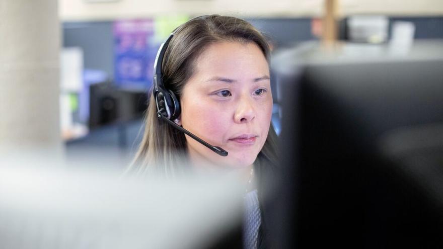 call center staff wearing a headset and looking at a computer monitor